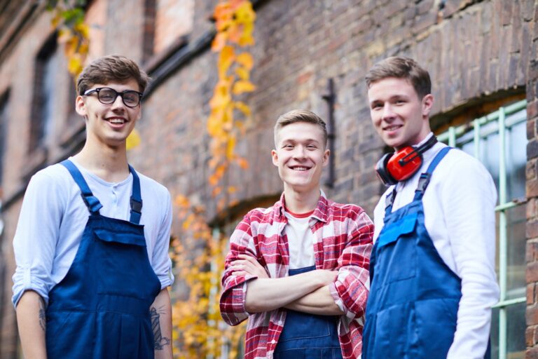 Cheerful young workers in uniforms outdoors